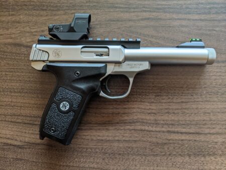 Smith & Wesson SW22 Victory pistol with HEX red dot sight on wooden surface