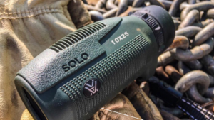 Vortex Solo 10x25 monocular in green resting on metal chains outdoors