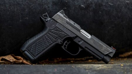 Wilson Combat SFX9 Handgun: Tested and Reviewed Black Wilson Combat 1911 pistol with textured grip panels resting on concrete surface.