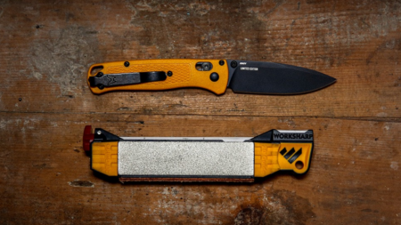 The Best Pocket Knife Sharpeners for Any Blade Orange Benchmade limited edition folding knife with WorkSharp pocket knife sharpener on wood surface