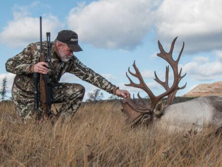 A hunter admires a caribou taken with a 6.5 Creedmoor.