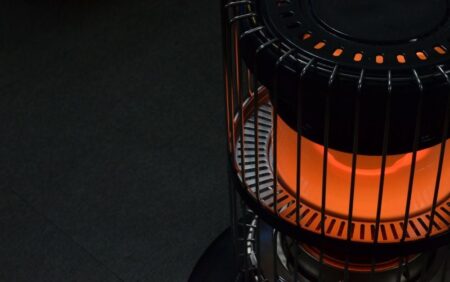 The 5 Best Kerosene Heaters of 2024 Glowing orange portable kerosene space heater with metal cage guard on dark floor