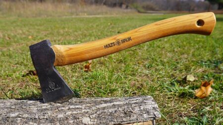 Hults Bruk hatchet with wooden handle resting on a log outdoors