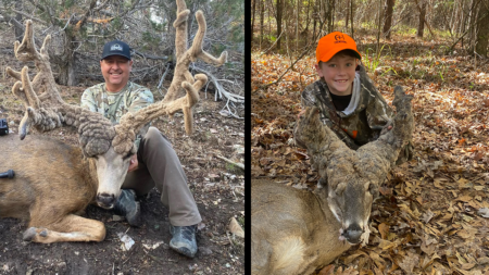 Two hunters posing with harvested whitetail bucks with unusual antler formations in woods.