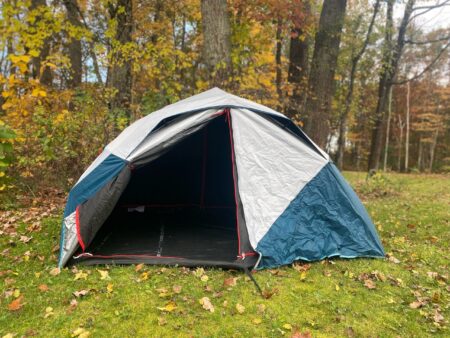 The 7 Best Instant Tents of 2024 Blue and gray dome camping tent pitched in autumn forest clearing with fallen leaves.