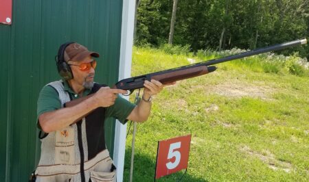 The 5 Best Do It All Shotguns Man wearing ear protection aims shotgun at skeet shooting range station 5.