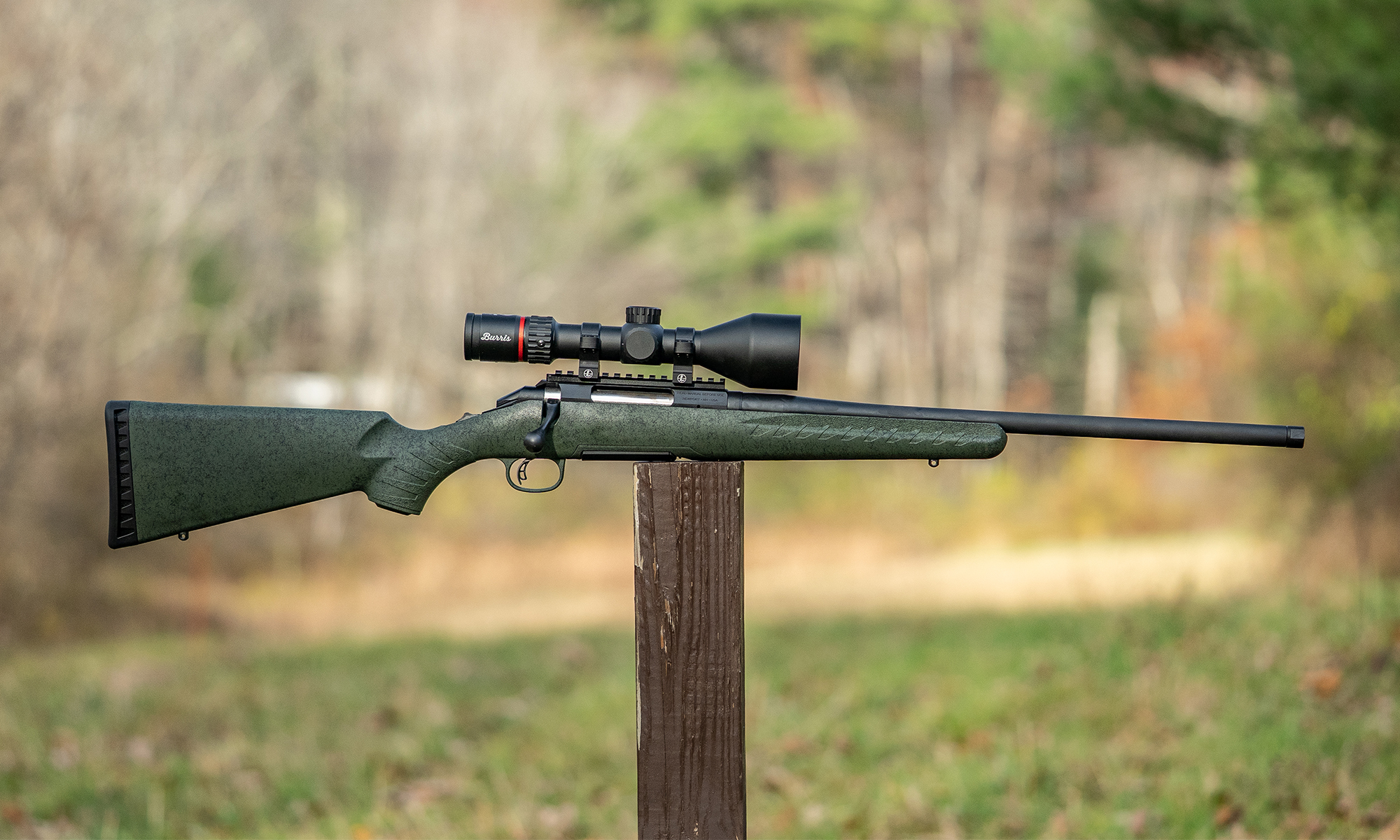 Glenfield Model A Rifle balanced on a post in a field.