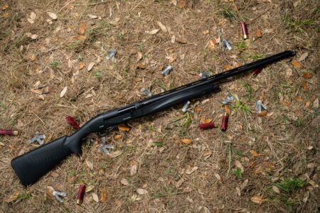 Shotgun Review: The Benelli Ethos Cordoba BE.S.T. Black semi-automatic shotgun lying on ground surrounded by spent shotgun shells