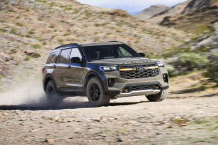 I Tested the New Ford Explorer Tremor to See if it Still Has Dirt in Its DNA A grey SUV speeds down a gravel road