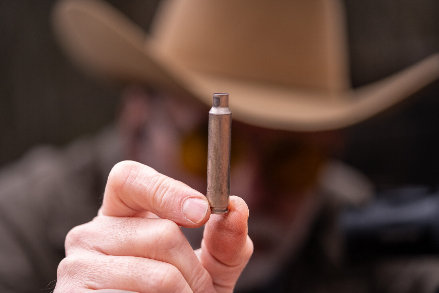 A hunter holds up a fired 270 Winchester cartridge.