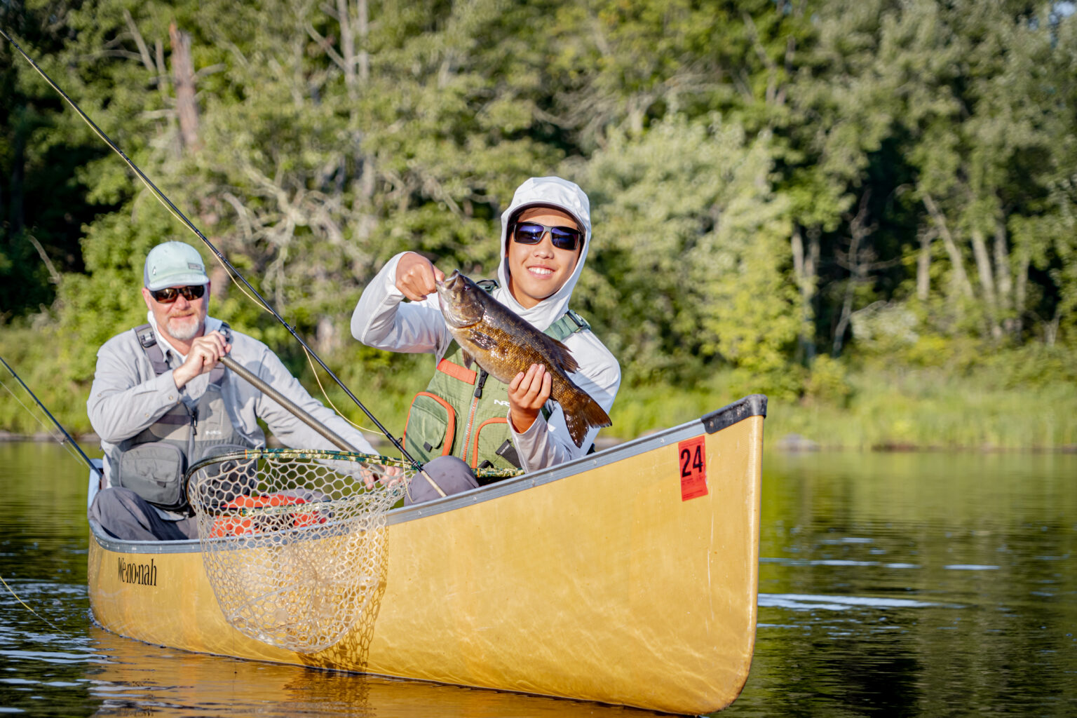 An angler poses with a smallmouth bass caught in the Boundary Waters Canoe Area Wilderness.