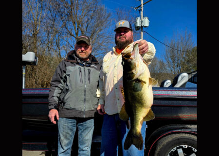 A Tennessee anglers poses with a pending state-record largemouth bass.