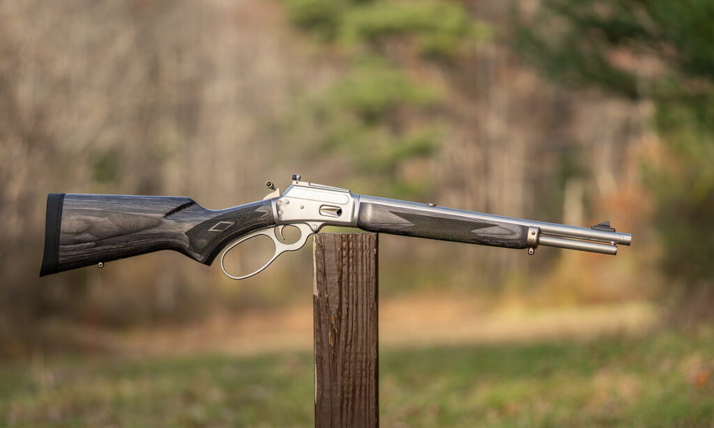Marlin 1894 Trapper 10mm Automatic rifle balance on a post in a field.