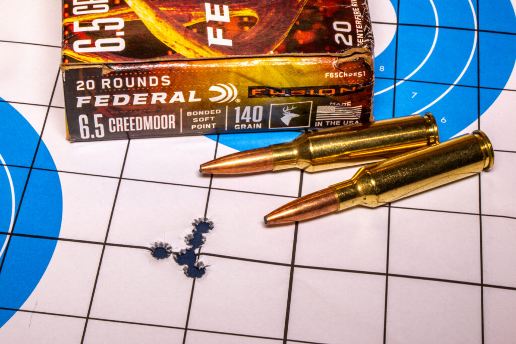 A targets with five bullet holes and ammo.