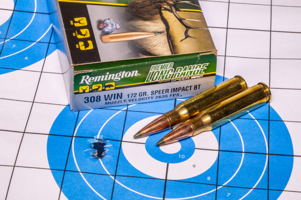 A target showing a group of bullet holes, with ammo. 