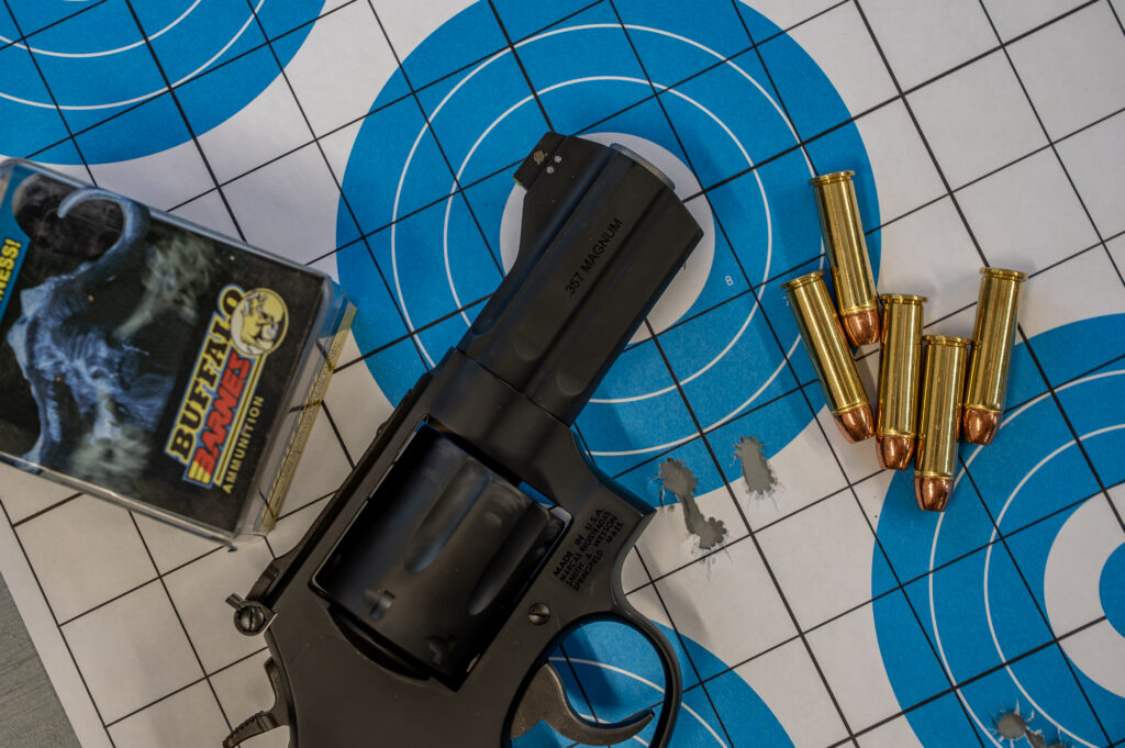 The new Lipsey's S&W Model 386 NightGuard on a target with bullet holes and ammo. 