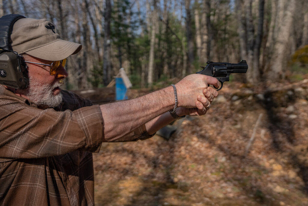 A man shoots the new Lipsey's S&W revolver from offhand on a range.
