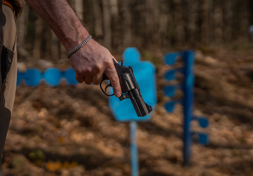 A man holds the new Lipsey's S&W Model 386 NightGuard on a shooting range.