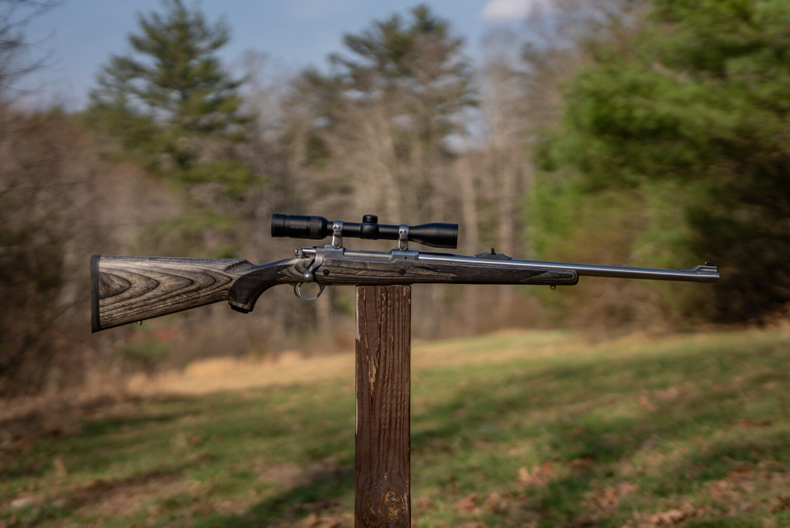 Lipsey's Ruger Alaskan Bush Rifle balanced on a post in a field.