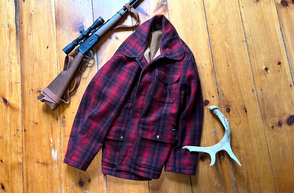 A Woolrich Buffalo Paid jacket with a Marlin lever-action rifle and a shed antler.