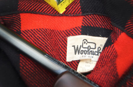 Closeup of a Woolrich tag in a red Buffalo-plaid jacket.