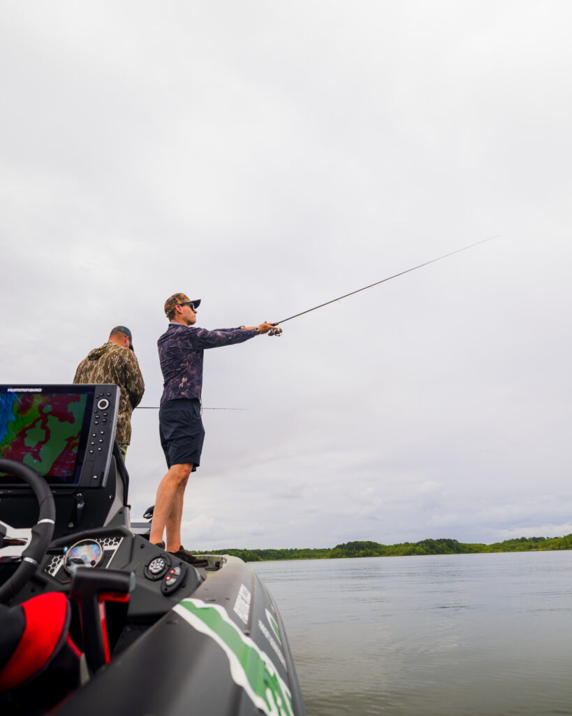 A fisherman casts on a fishing boat.