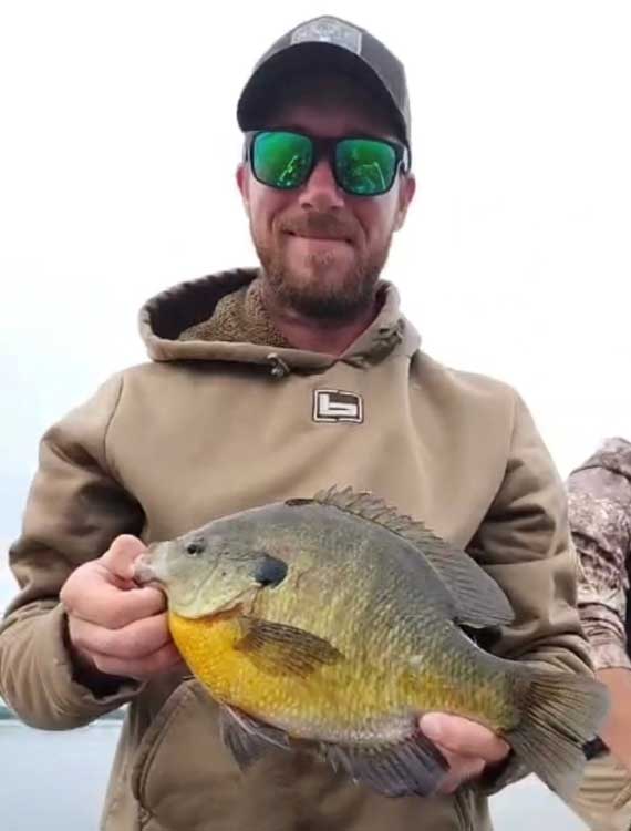 An angler poses with a state-record bluegill. 