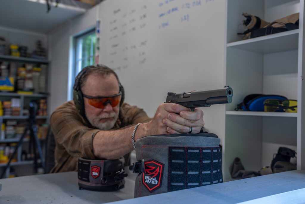 A man shoots the new Dan Wesson Kodiak 1911 from inside a shooting house.