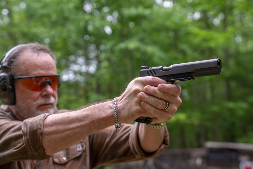 A man shoots the new Dan Wesson Kodiak 1911 in the woods.