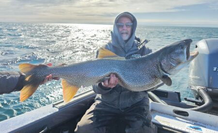 An angler poses with a state-record lake trout caught in Minnesota.