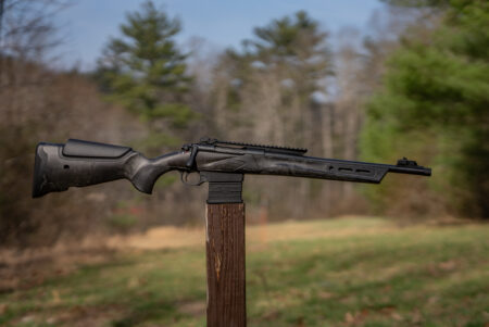 Franchi MULE rifle balanced on a post in a field