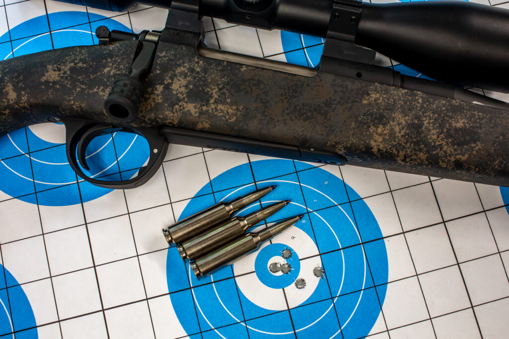 Target, rifle, and three 6.5 Creedmoor +PEAK cartridges.