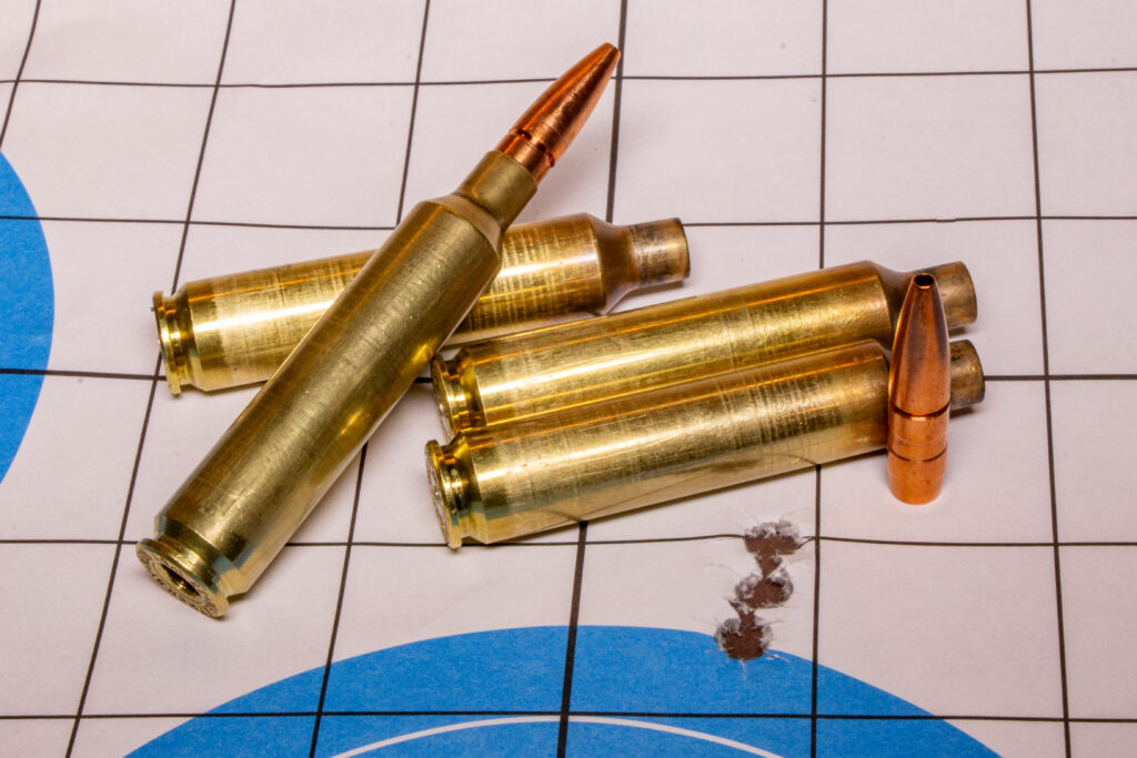 A rifle target with bullet holes and ammo