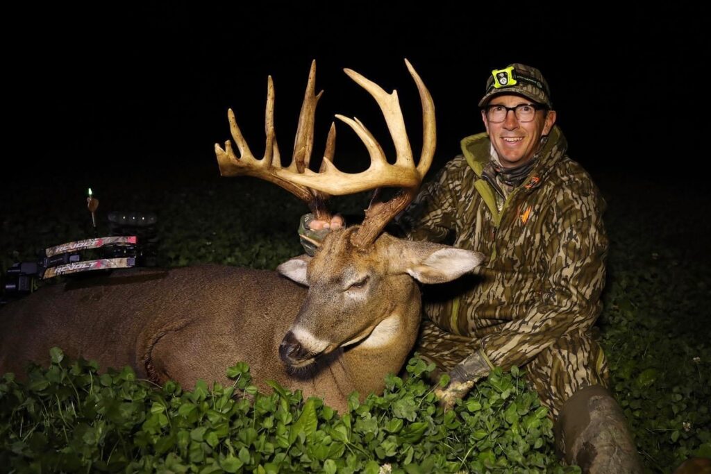 A hunter poses with a huge whitetail buck taken in a bedding area