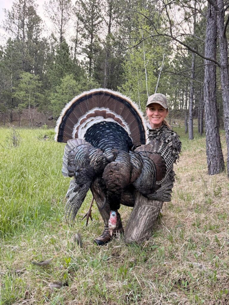 A hunter poses with her fist-ever Merriam's turkey. 