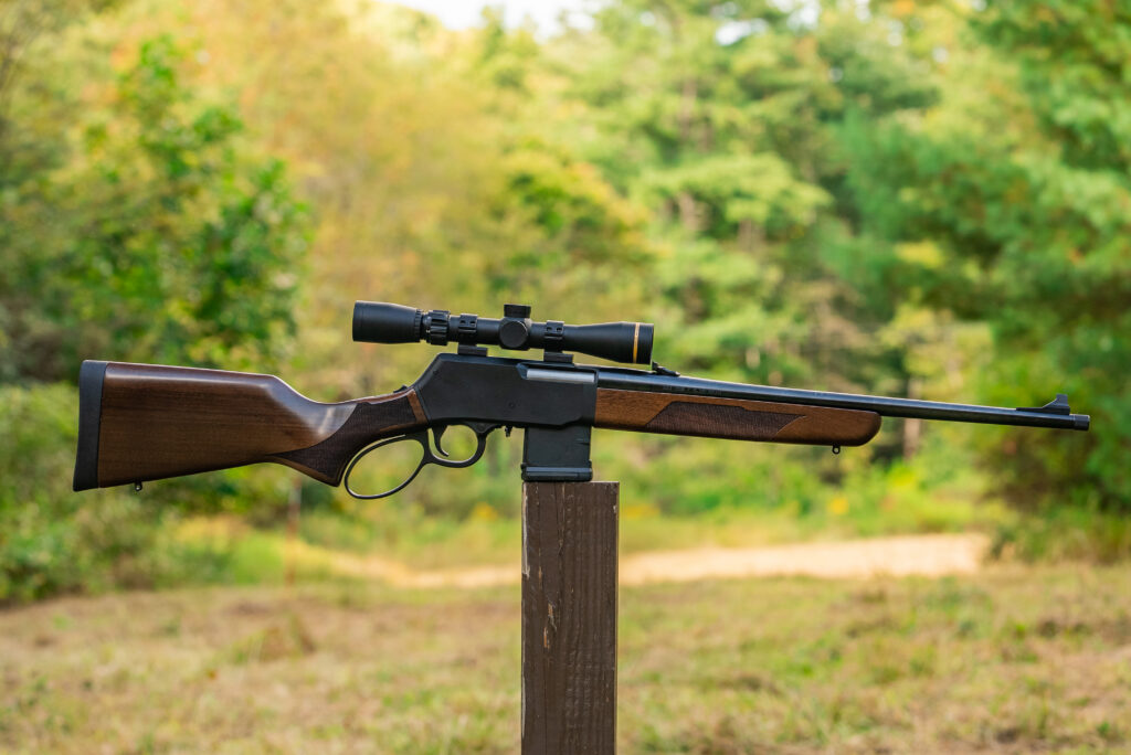 Henry Lever Action Supreme rifle balanced on a post in a field