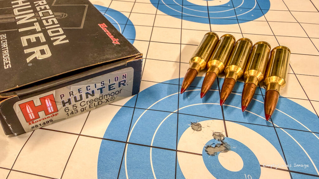 A group of shots fires into a rifle target, with ammo
