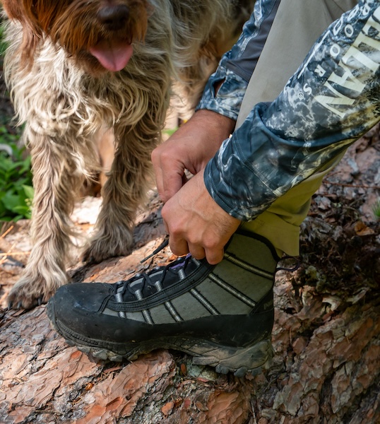 Angler lacing up Patagonia Forra wading boots