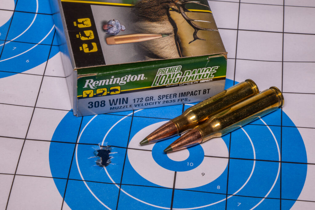 A small group in a rifle target with ammo on top