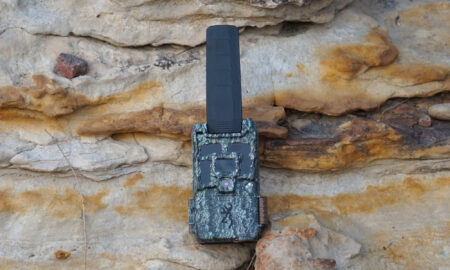 Browning Defender Pro Scout MAX HD DV cellular trail camera resting on a rock.