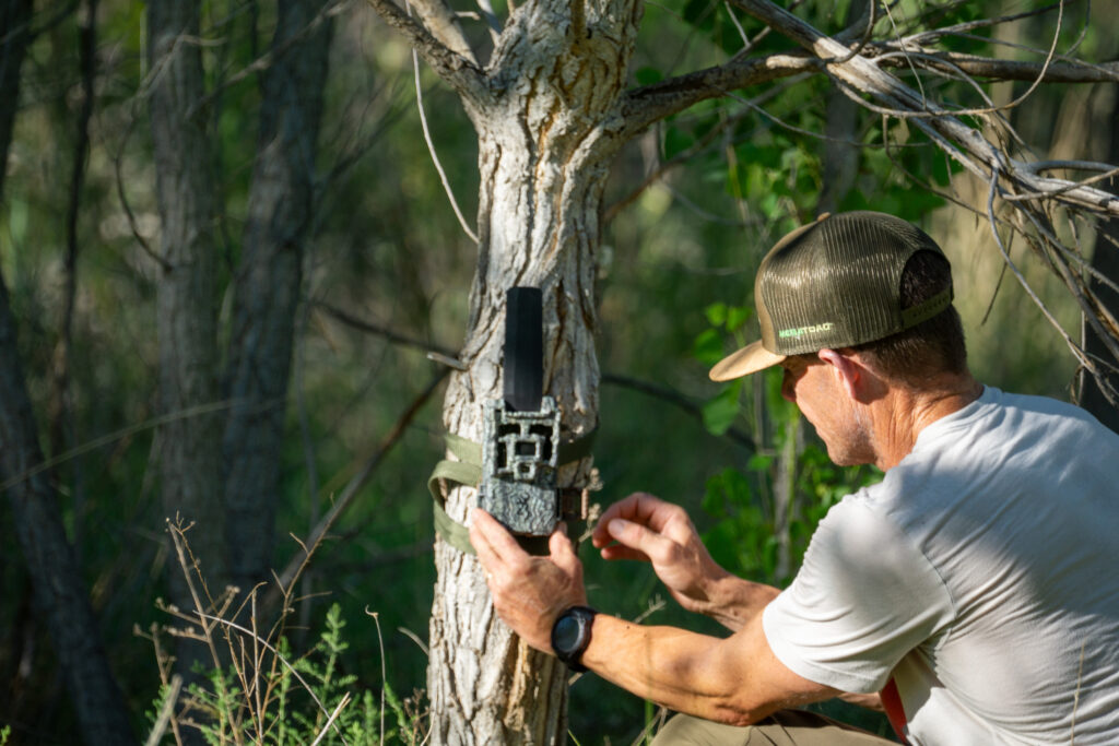 A hunter sets up a Browning Defender Pro Scout MAX HD DV trail camera