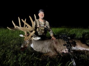A kentucky bow hunter poses with a trophy whitetail in full velvet.