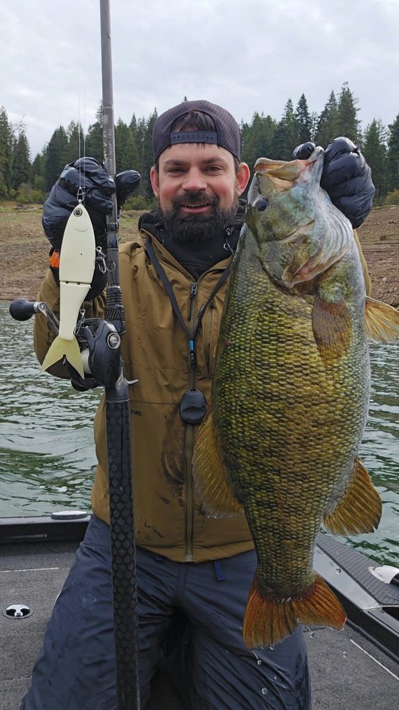 An angler poses with a trophy-sized smallmouth bass caught on a glide bait. 