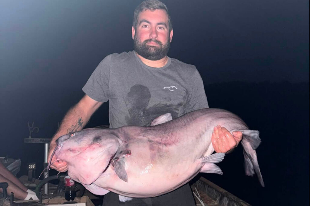 Angler’s State-Record Catfish Could Net Him a $20,000 Prize An angler poses with a state-record catfish.