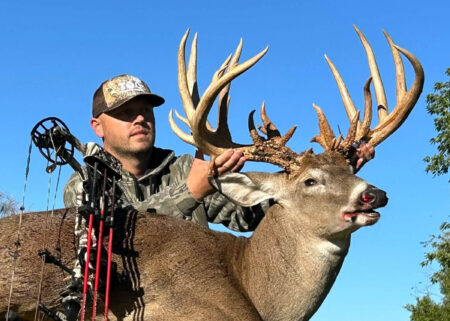 A hunter poses with a trophy whitetail taken in Indiana.