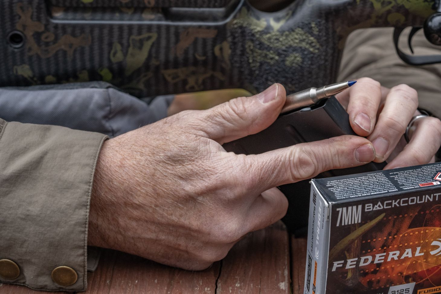 A shooter loads a rifle's magazine with 7mm Backcountry ammo. 