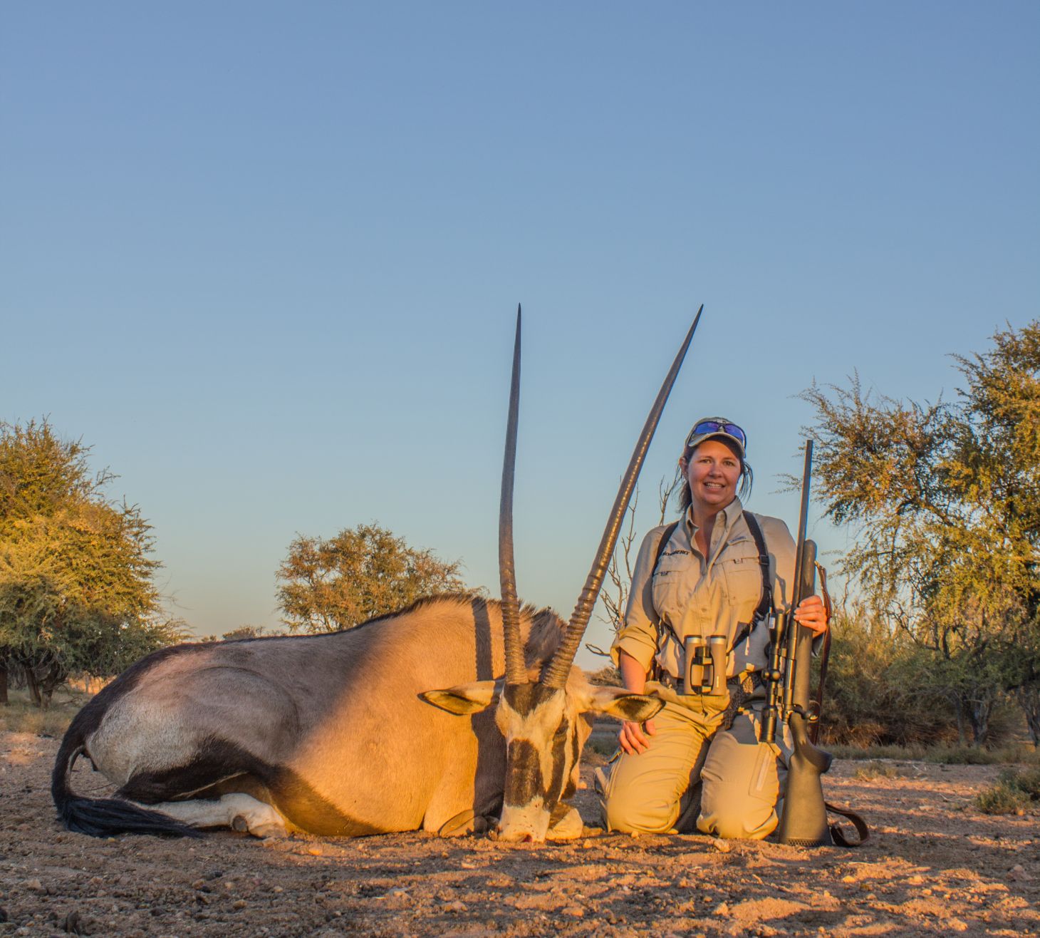 A female hunter poses with a Oryx in Africa. 
