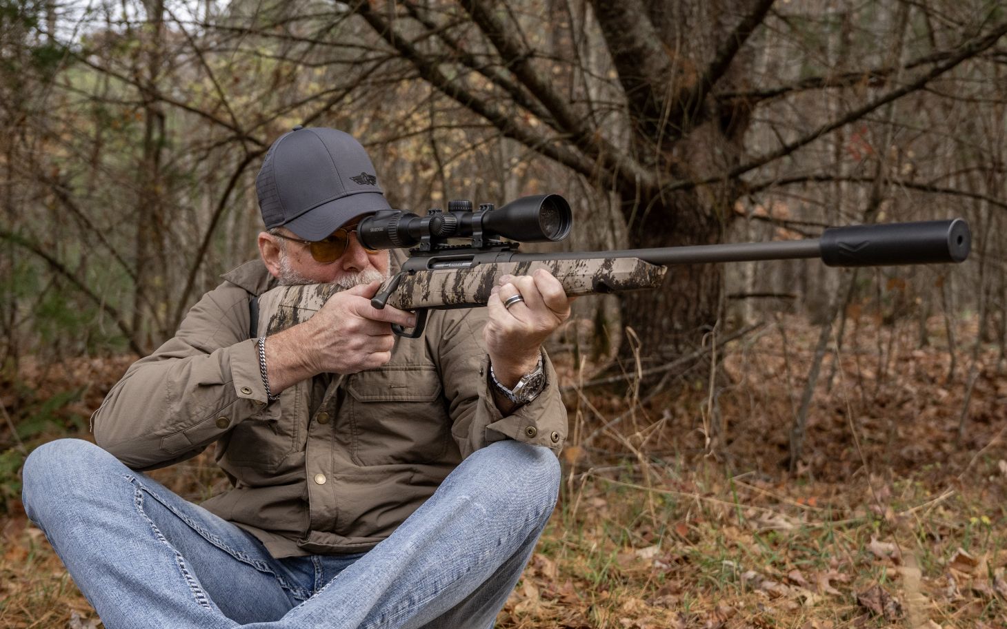 A shooter fires the new Savage Axis 2 pro rifle with a suppressor from the sitting position. 