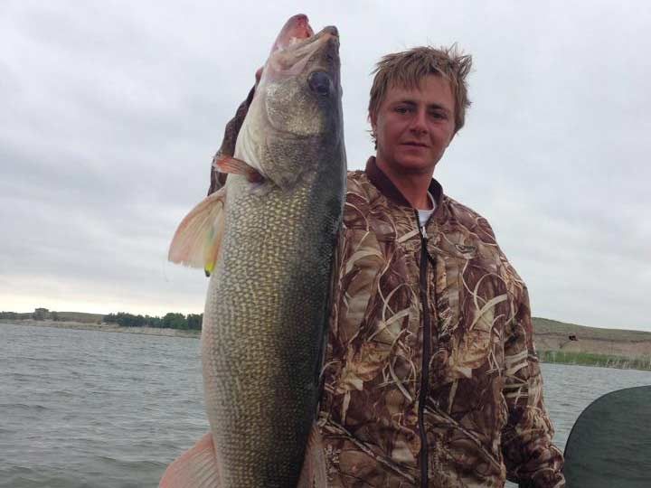 Man holding up walleye fish.