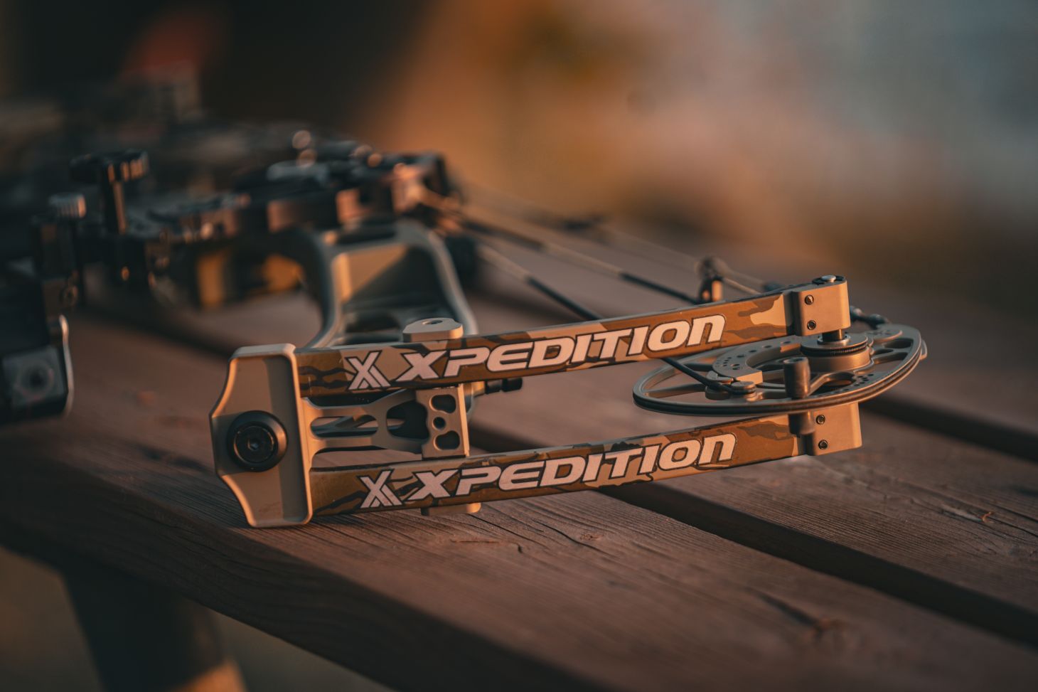 The new Xpedition Xlite 32 compound bow laying on a wood table outdoors.